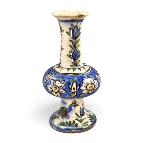 fig 2. A late Qajar Persian polychrome ceramic vase featuring a central bulbous knop, flared rim, crackle glaze finish, and painted blue and green floral motifs.