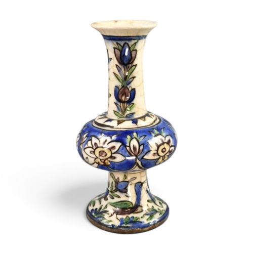 fig 4. A late Qajar Persian polychrome ceramic vase featuring a central bulbous knop, flared rim, crackle glaze finish, and painted blue and green floral motifs.