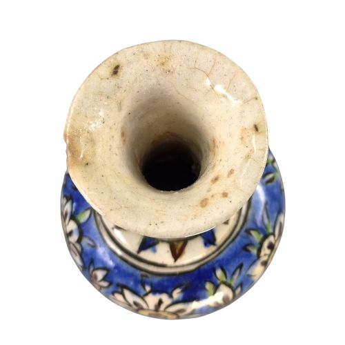 fig 5. A late Qajar Persian polychrome ceramic vase featuring a central bulbous knop, flared rim, crackle glaze finish, and painted blue and green floral motifs.