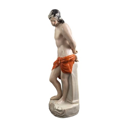 fig 4. A Victorian earthenware figurine depicting Christ standing at a column draped in a terracotta-coloured cloth on a scrollwork base.