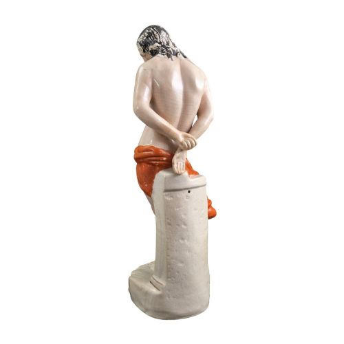 fig 5. A Victorian earthenware figurine depicting Christ standing at a column draped in a terracotta-coloured cloth on a scrollwork base.