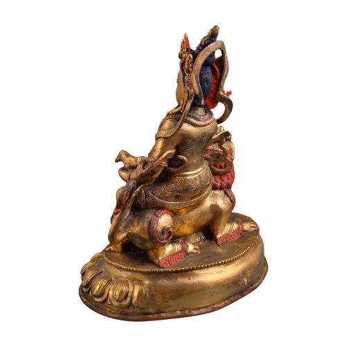 fig 4. A gilt bronze figure of the deity Jambhala crowned and adorned with jewellery, seated upon a snow lion atop an oval lotus pedestal base with red and blue painted accents.