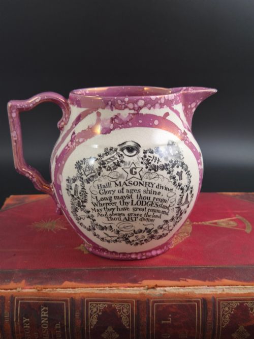 fig 3. An English earthenware jug featuring pink splash lustre glaze trim and a central black transfer-printed Masonic emblem.