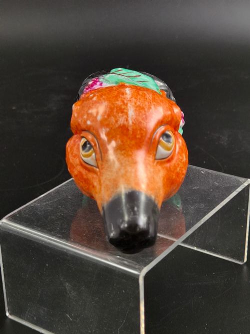 fig 1. A 19th-century Royal Staffordshire porcelain stirrup cup molded in the form of a fox head with painted orange, black, green, and purple enamels.