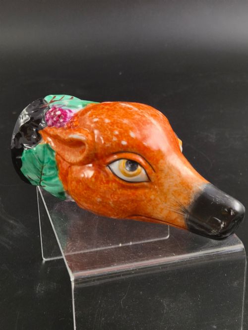 fig 2. A 19th-century Royal Staffordshire porcelain stirrup cup molded in the form of a fox head with painted orange, black, green, and purple enamels.