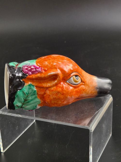 fig 3. A 19th-century Royal Staffordshire porcelain stirrup cup molded in the form of a fox head with painted orange, black, green, and purple enamels.