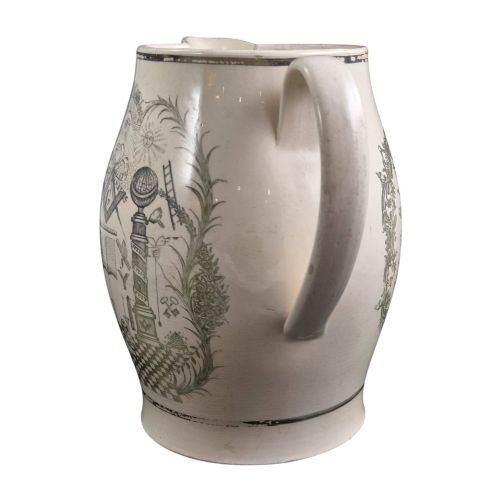 fig 5. A Georgian Staffordshire creamware jug featuring transfer-printed olive-green Masonic iconography framed by a leafy scrollwork wreath.