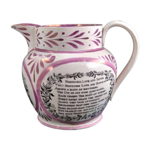 fig 4. An antique white earthenware jug decorated with pink metallic lustre foliage borders and a black transfer-printed Masonic emblem featuring twin columns and symbolic motifs.