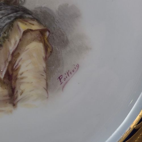 fig 1. A circular porcelain cabinet plate featuring a central hand-painted portrait of a woman framed by a deep cobalt blue rim with gold scrollwork.
