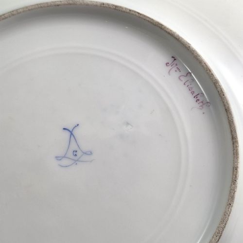 fig 4. A circular porcelain cabinet plate featuring a central hand-painted portrait of a woman framed by a deep cobalt blue rim with gold scrollwork.
