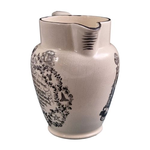 fig 4. A creamware ceramic jug featuring detailed black transfer prints of Masonic emblems, including classical columns, a beehive, and a coat of arms.