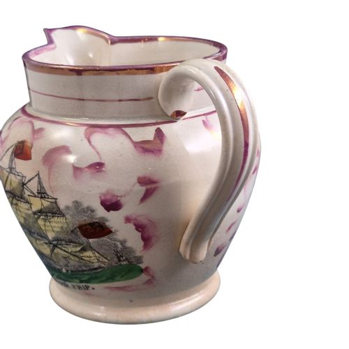 fig 4. An antique cream earthenware jug featuring pink splash lustre decoration and a hand-coloured transfer print of Masonic coats of arms.