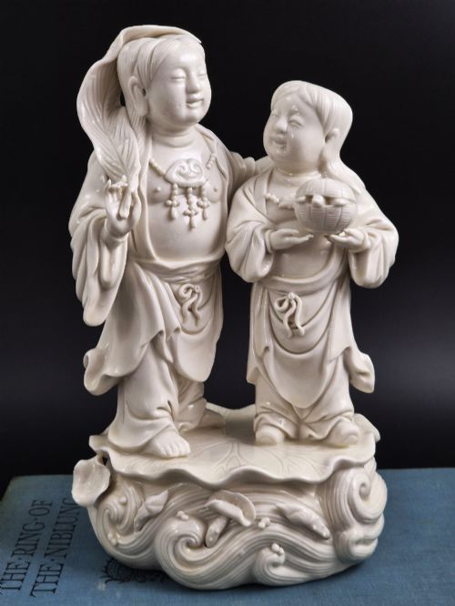 fig 2. A Qing Dynasty Blanc-de-Chine white porcelain figure group depicting the Hehe Erxian standing on a stylised lotus and wave base.