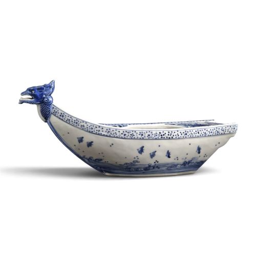 fig 4. A Japanese blue and white porcelain vessel shaped like a boat featuring a carved dragon figurehead at the prow.