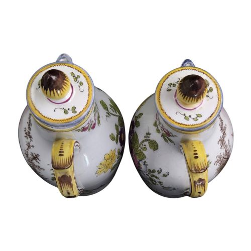 fig 1. A pair of 18th-century white tin-glazed earthenware oil and vinegar jugs decorated with hand-painted floral motifs and fitted with yellow finial covers.