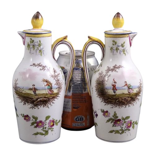 fig 2. A pair of 18th-century white tin-glazed earthenware oil and vinegar jugs decorated with hand-painted floral motifs and fitted with yellow finial covers.