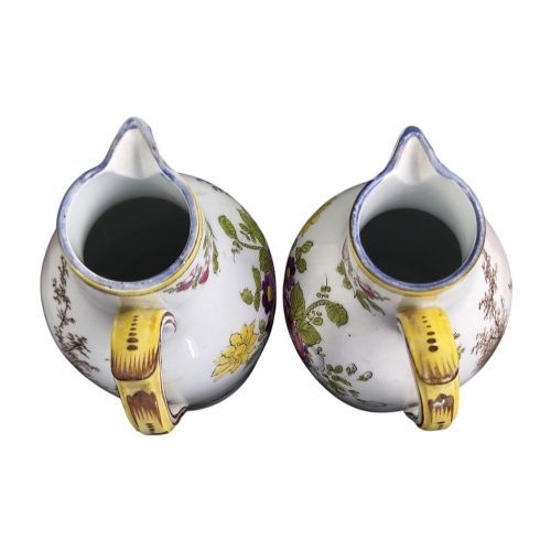 fig 4. A pair of 18th-century white tin-glazed earthenware oil and vinegar jugs decorated with hand-painted floral motifs and fitted with yellow finial covers.