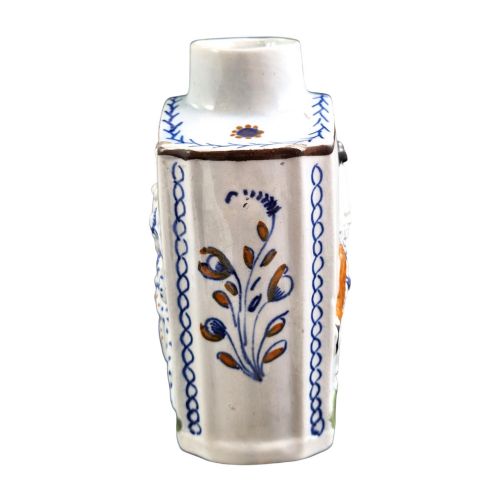 fig 2. An 18th-century Prattware earthenware tea canister featuring relief-moulded depictions of two Georgian Macaroni figures in blue, ochre, and green underglaze glazes against an off-white background.