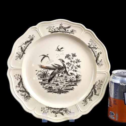 fig 1. A pair of round cream-coloured earthenware plates featuring monochrome transfer prints of birds and moulded scalloped rims.