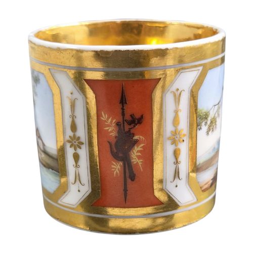 fig 4. A French Old Paris porcelain cup and saucer featuring gilded trim, interior gold wash, and hand-painted panels depicting rural figures.