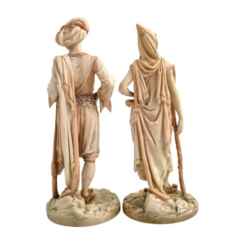 fig 2. A pair of late Victorian Royal Worcester blush ivory porcelain figures depicting an Indian man and woman in detailed traditional attire with gilded accents.