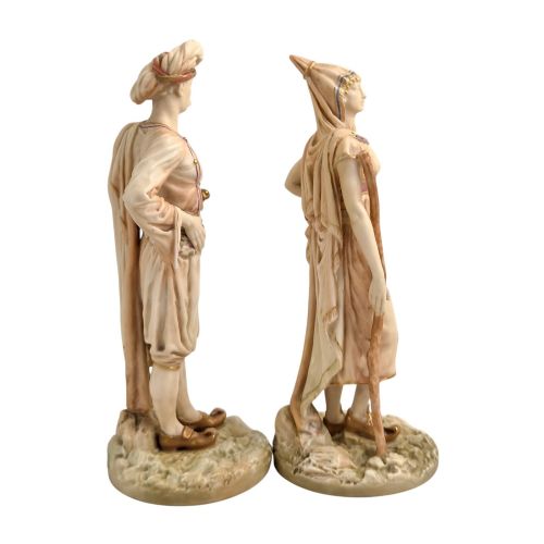 fig 3. A pair of late Victorian Royal Worcester blush ivory porcelain figures depicting an Indian man and woman in detailed traditional attire with gilded accents.