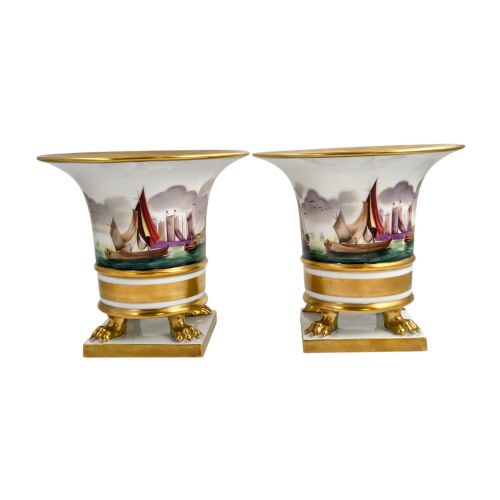 fig 2. A pair of flared white porcelain Empire-style vases decorated with hand-painted sailing ships and supported by gilded paw feet.