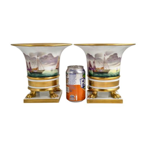 fig 4. A pair of flared white porcelain Empire-style vases decorated with hand-painted sailing ships and supported by gilded paw feet.