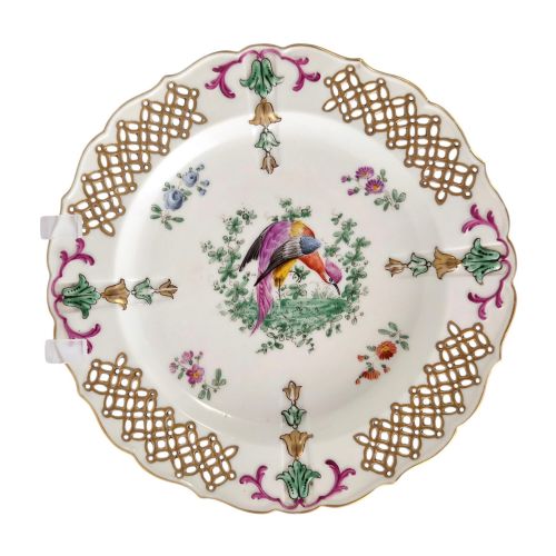 fig 5. Set of three white porcelain cabinet plates featuring pierced lattice rims decorated with gold gilding, pink scrolls, green accents, and hand-painted exotic birds in the centre.