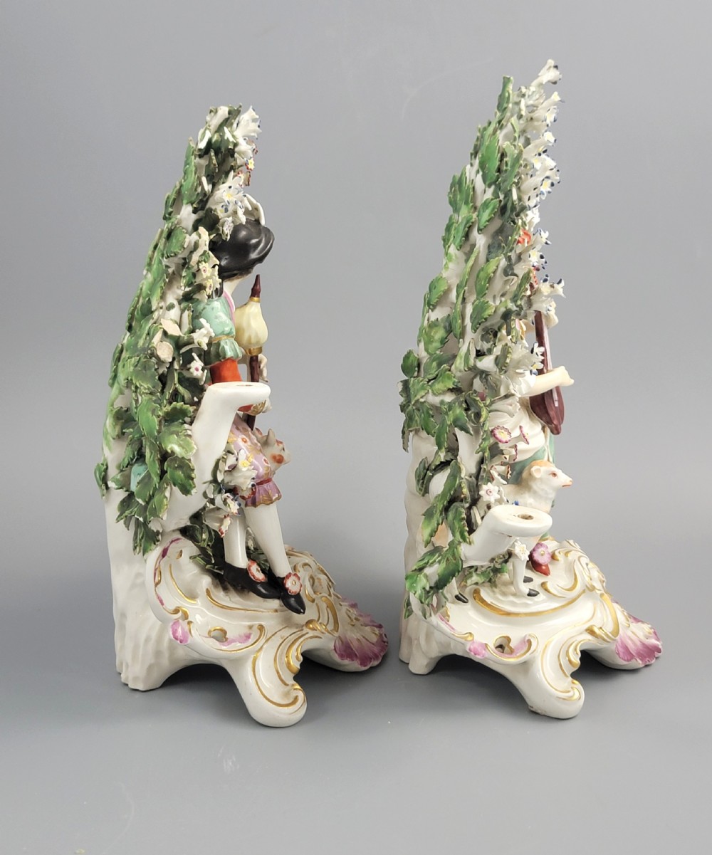 A pair of 18th-century English Derby porcelain candlestick figures depicting musicians surrounded by intricate floral bocage on Rococo scroll bases. View IV