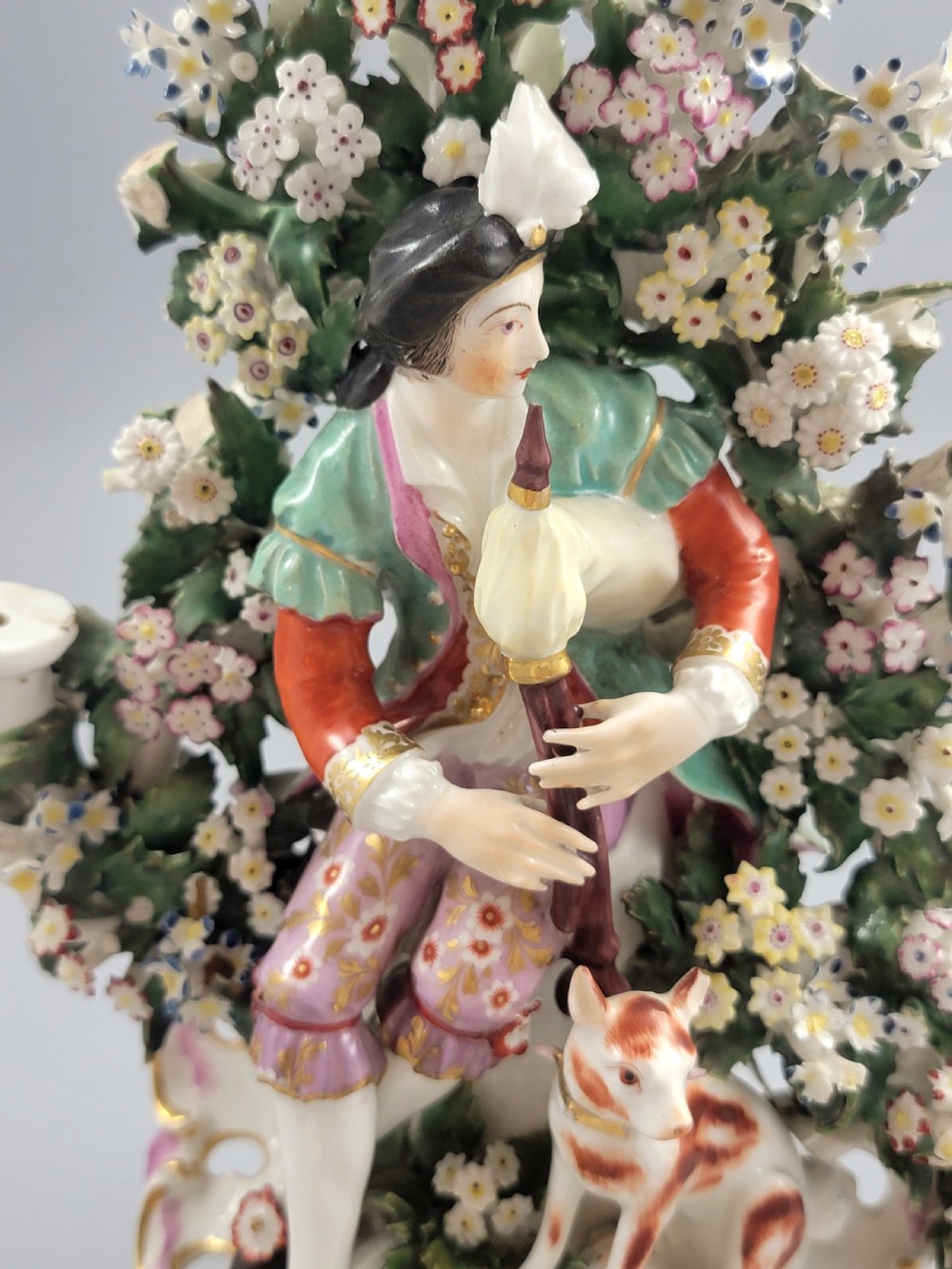 A pair of 18th-century English Derby porcelain candlestick figures depicting musicians surrounded by intricate floral bocage on Rococo scroll bases. View VII