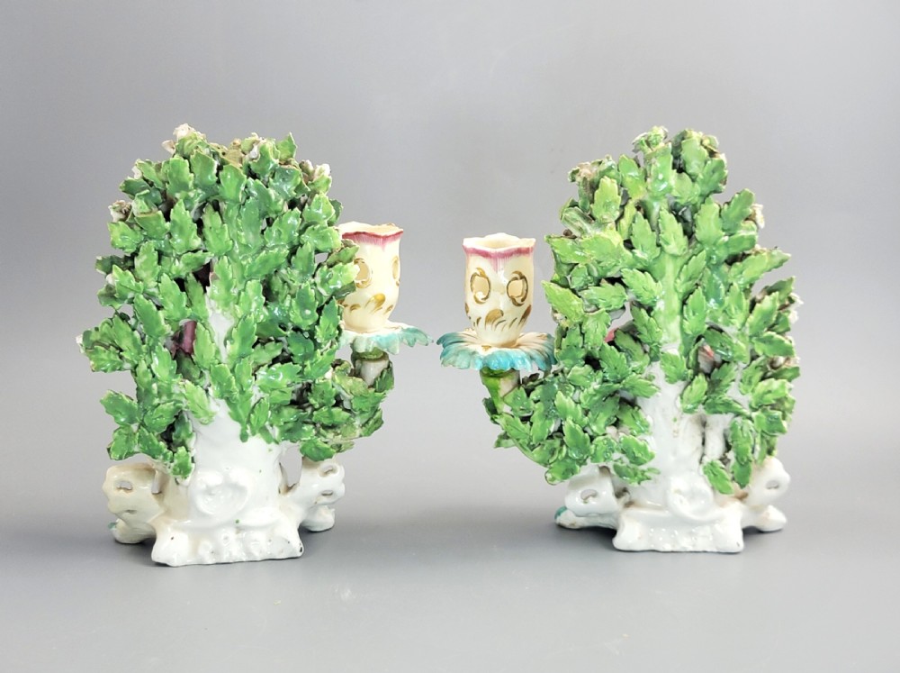 A pair of 18th-century soft-paste Derby porcelain candlesticks depicting a male and female musician seated before leafy floral bocage backdrops. View III