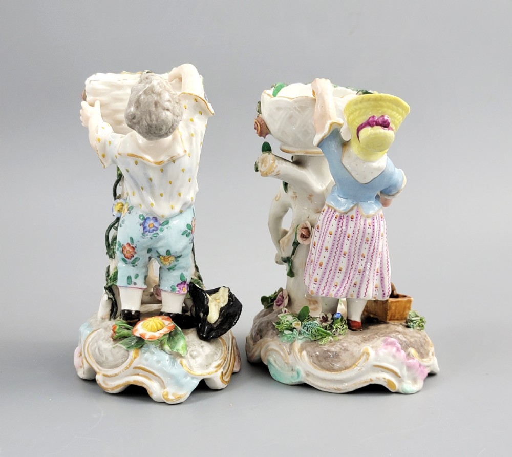 A pair of late nineteenth-century Volkstedt porcelain sweetmeat figures featuring a male and female figure picking fruit beside basket dishes on rococo bases. View V