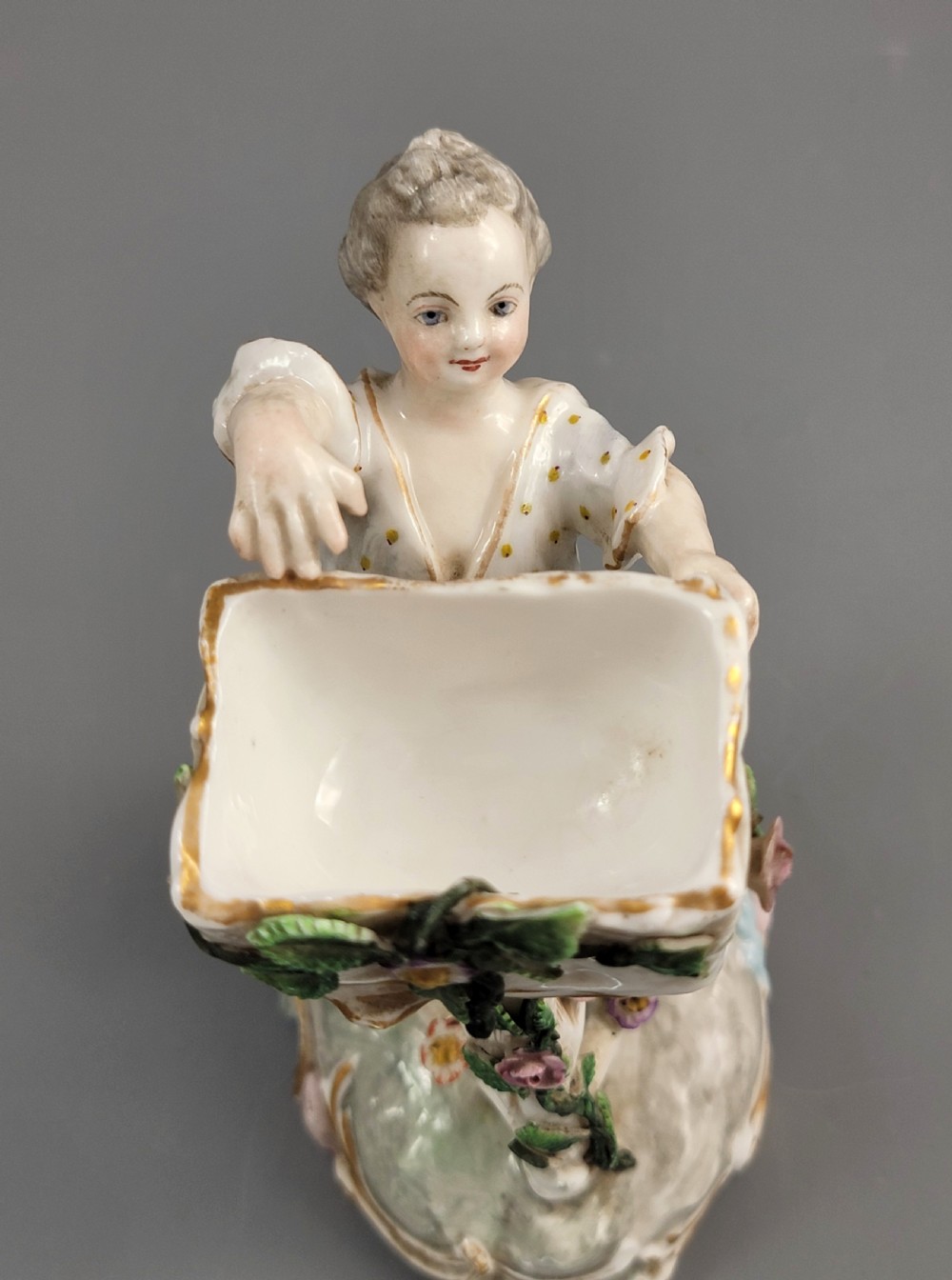 A pair of late nineteenth-century Volkstedt porcelain sweetmeat figures featuring a male and female figure picking fruit beside basket dishes on rococo bases. View VI