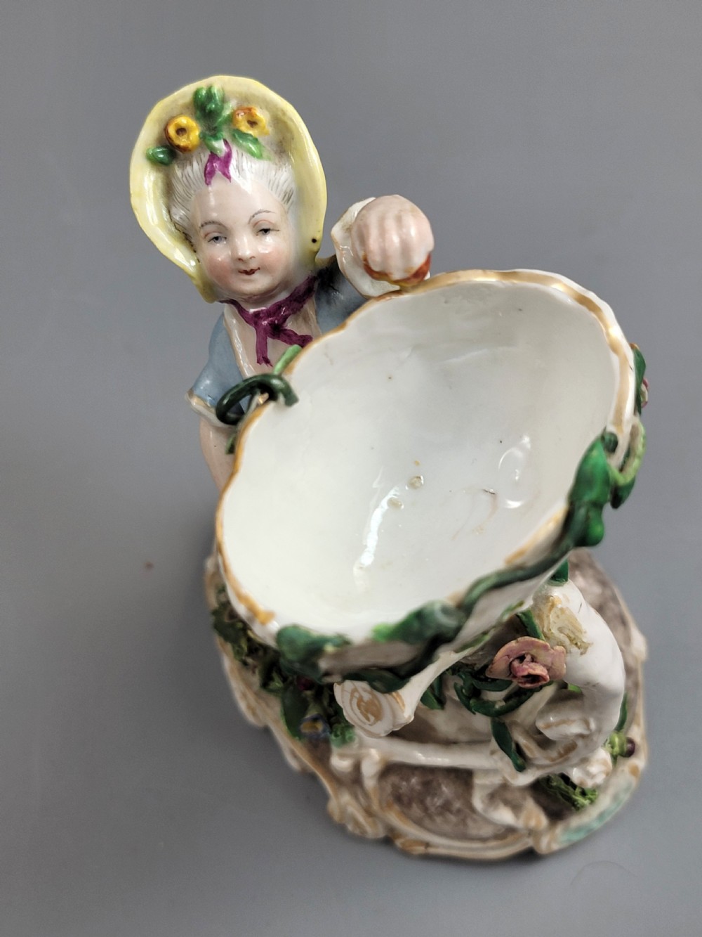 A pair of late nineteenth-century Volkstedt porcelain sweetmeat figures featuring a male and female figure picking fruit beside basket dishes on rococo bases. View VIII