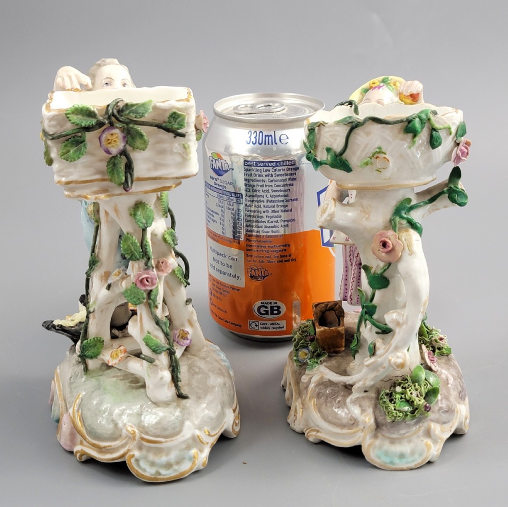 A pair of late nineteenth-century Volkstedt porcelain sweetmeat figures featuring a male and female figure picking fruit beside basket dishes on rococo bases. View IX