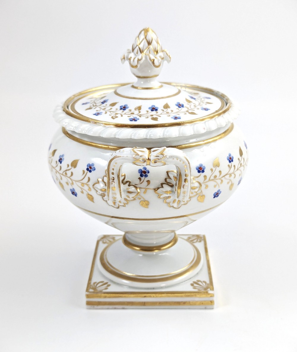 A Regency Flight, Barr and Barr Worcester white porcelain sauce tureen with lid, featuring gilt leaves, blue flowers, twin handles, and a square base. View II