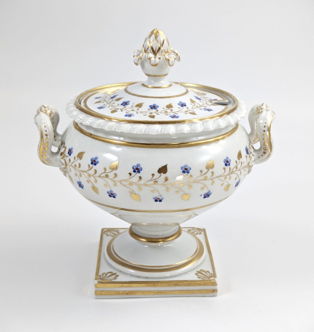 A Regency Flight, Barr and Barr Worcester white porcelain sauce tureen with lid, featuring gilt leaves, blue flowers, twin handles, and a square base. View III