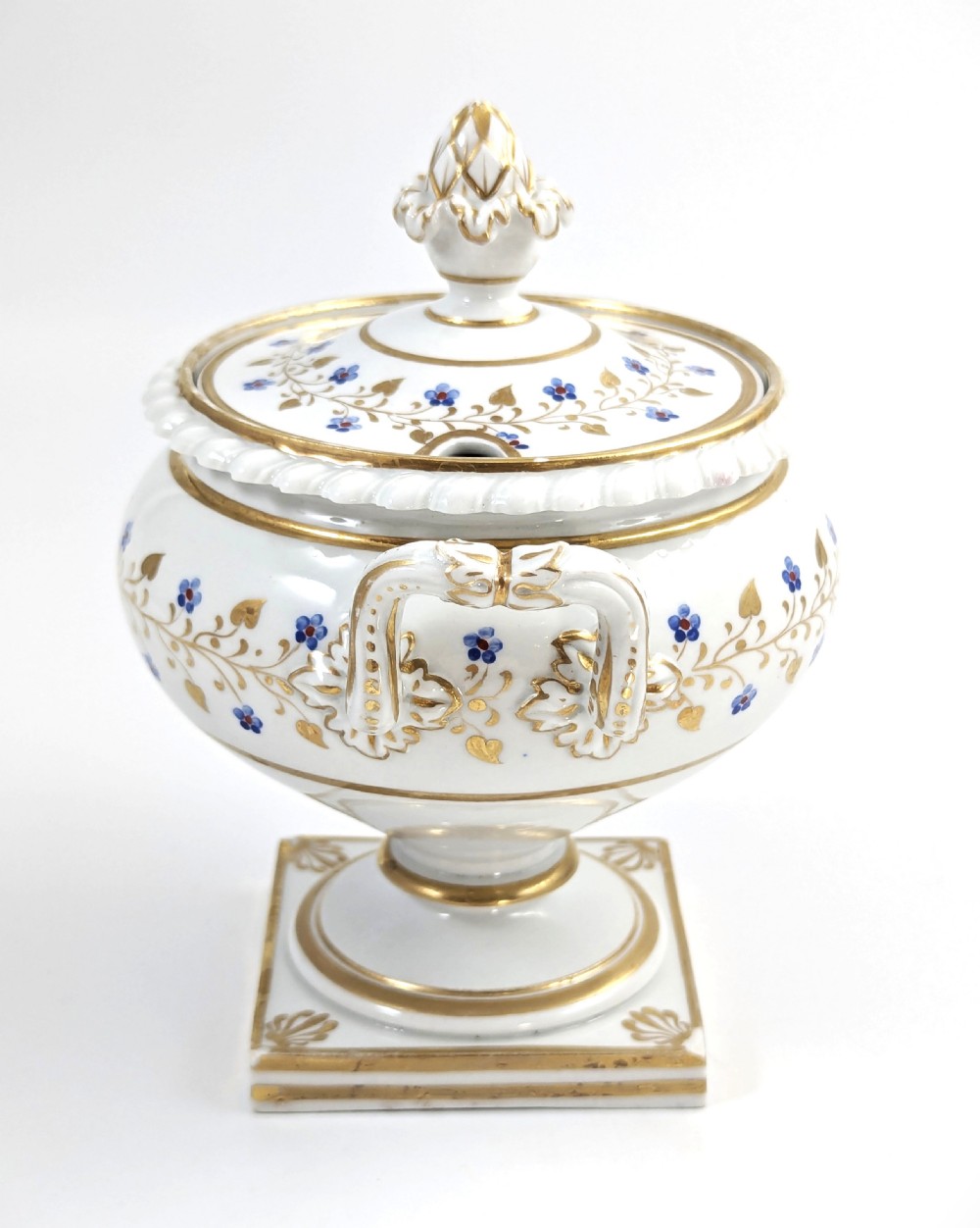 A Regency Flight, Barr and Barr Worcester white porcelain sauce tureen with lid, featuring gilt leaves, blue flowers, twin handles, and a square base. View IV