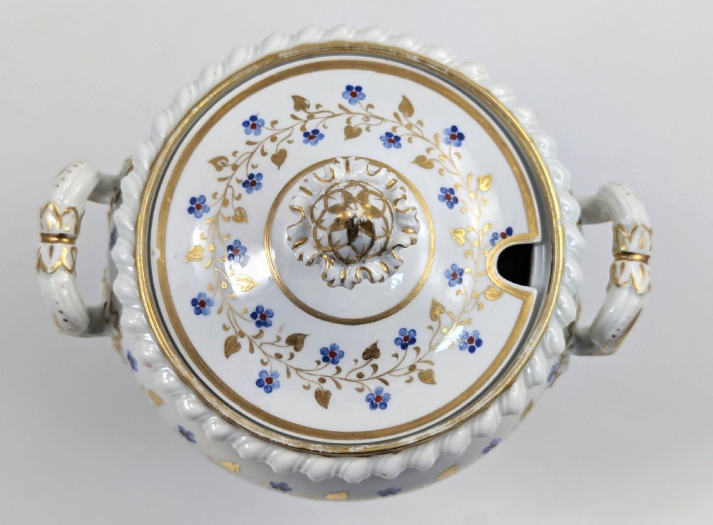A Regency Flight, Barr and Barr Worcester white porcelain sauce tureen with lid, featuring gilt leaves, blue flowers, twin handles, and a square base. View V