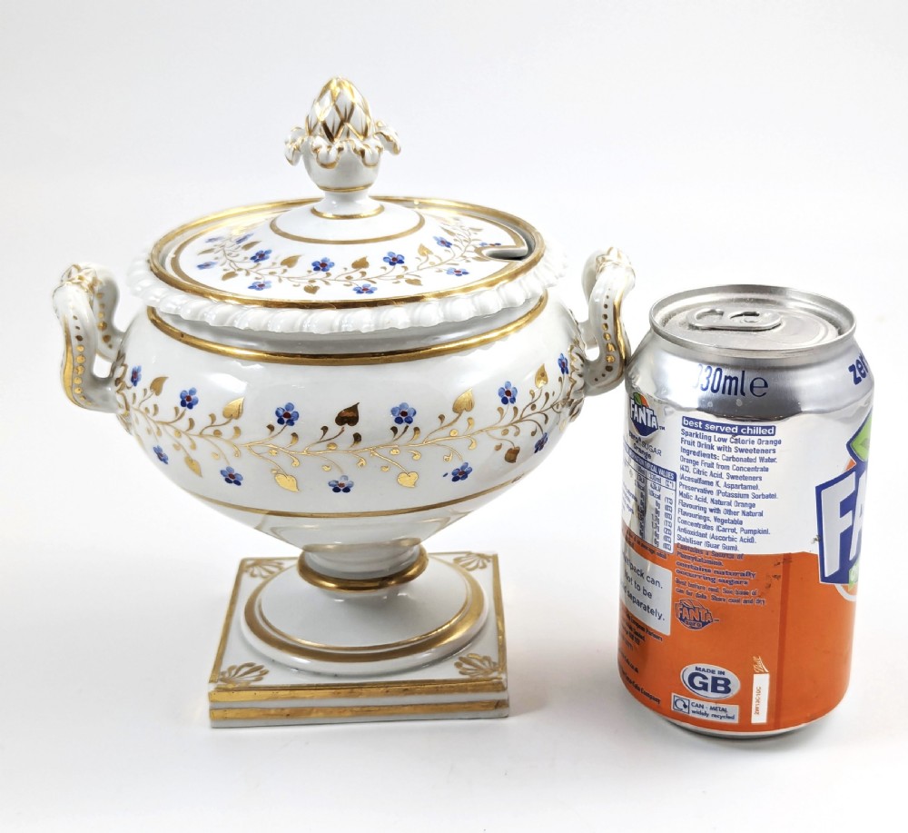 A Regency Flight, Barr and Barr Worcester white porcelain sauce tureen with lid, featuring gilt leaves, blue flowers, twin handles, and a square base. View IX
