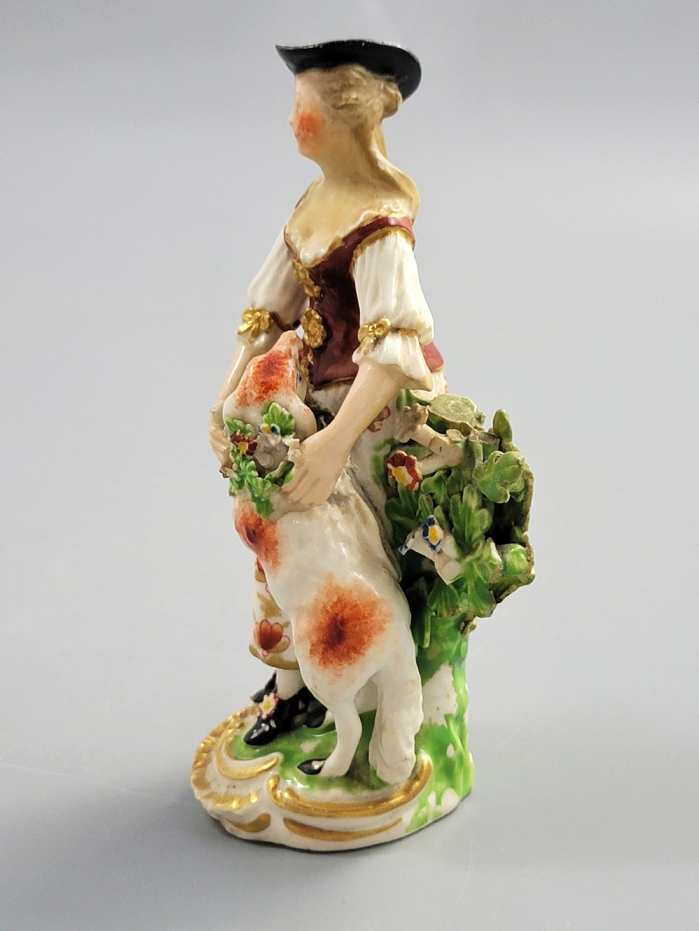 An 18th-century Derby soft-paste porcelain figurine depicting a shepherdess with a lamb on a gilded Rococo scroll base. View III