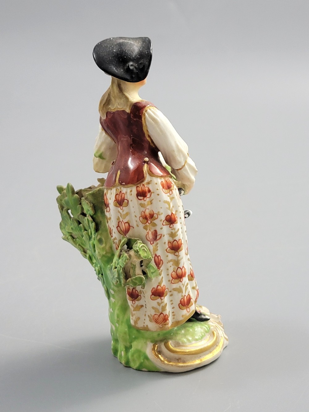 An 18th-century Derby soft-paste porcelain figurine depicting a shepherdess with a lamb on a gilded Rococo scroll base. View V