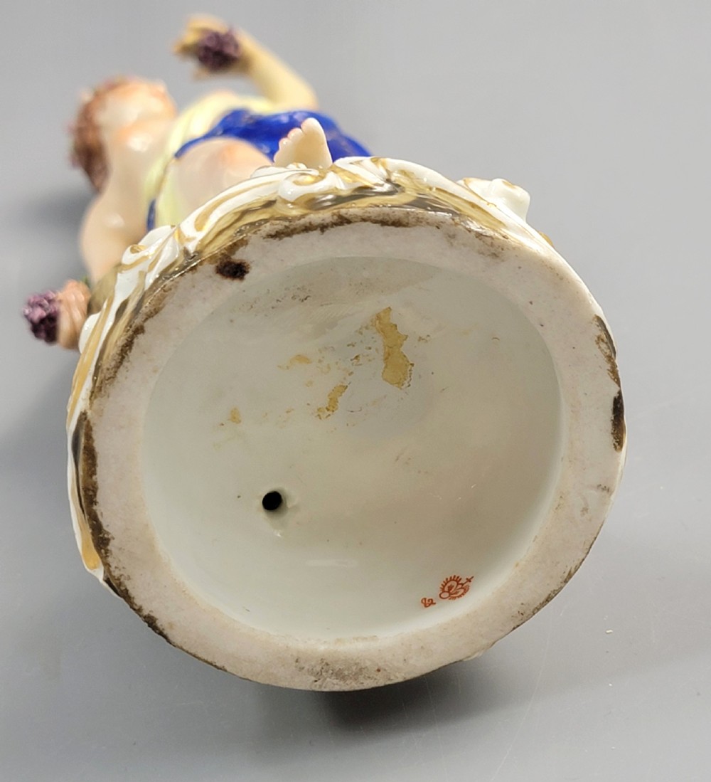A nineteenth-century Samson Paris porcelain figure of a Bacchante wearing a patterned cobalt blue drape and holding grapes on a scrollwork base. View VII