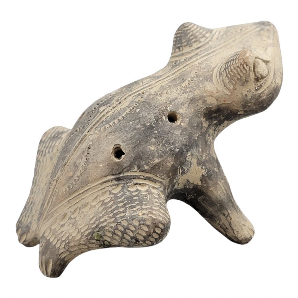 A sculpted grey earthenware whistle shaped like a frog with incised line details and finger holes along its back. View IV