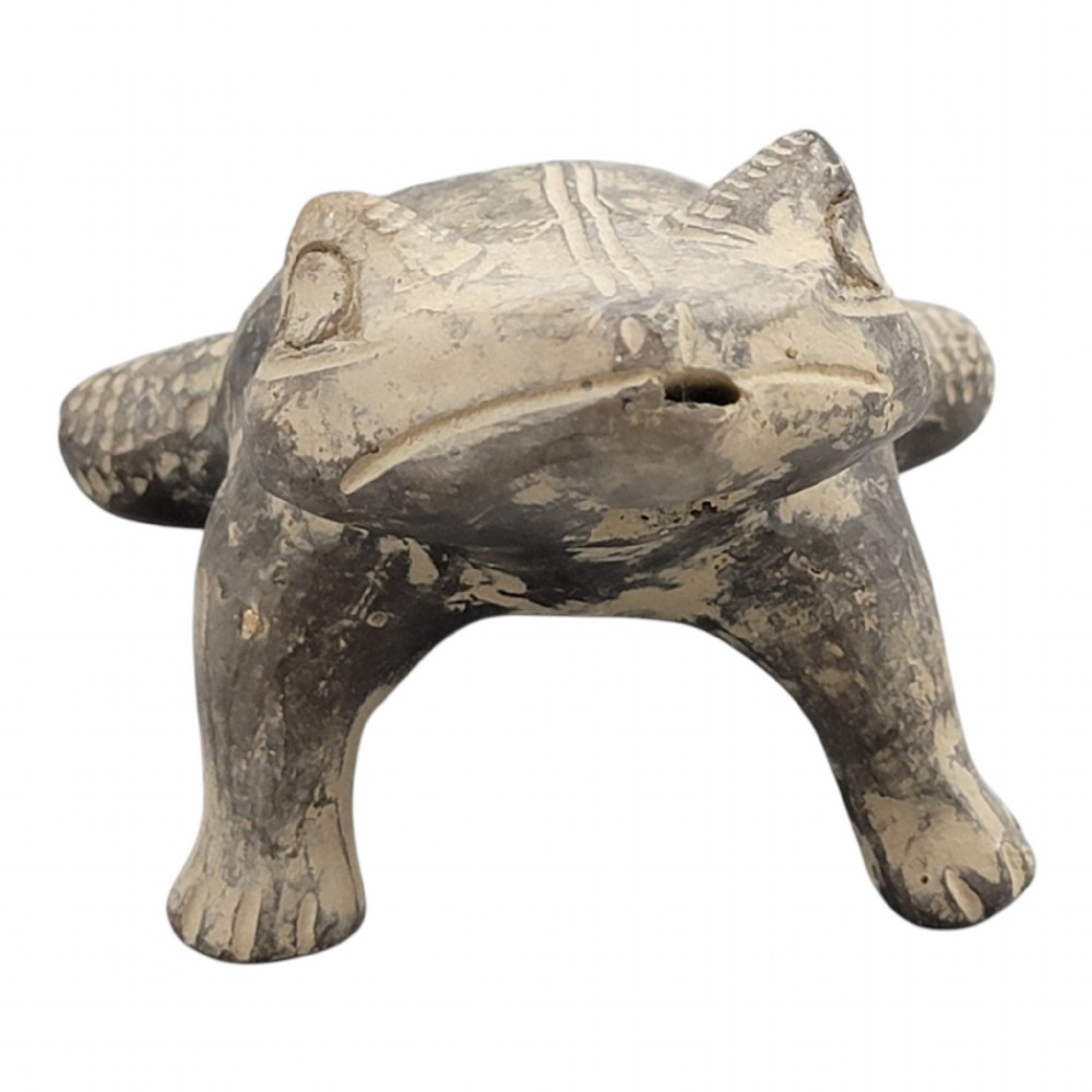 A sculpted grey earthenware whistle shaped like a frog with incised line details and finger holes along its back. View VI