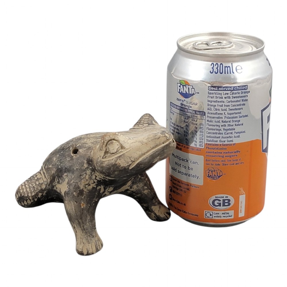 A sculpted grey earthenware whistle shaped like a frog with incised line details and finger holes along its back. View IX