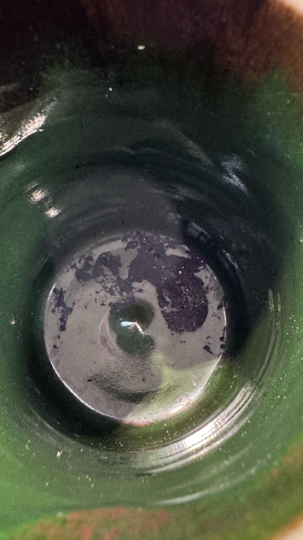 A dark ribbed ceramic mug featuring a dripping flambe glaze rim and an applied relief figure of a seated Japanese sennin. View XV