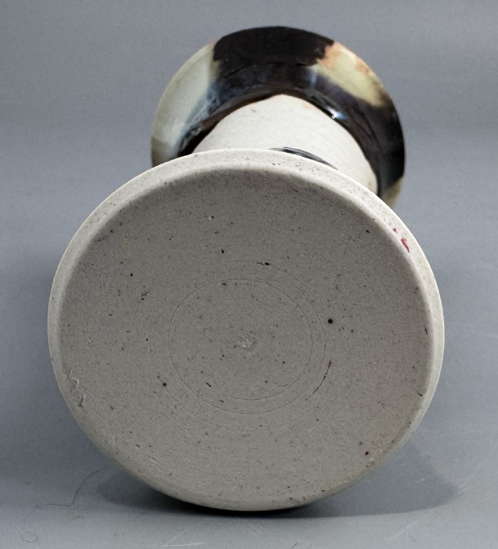 A Japanese Sumida Gawa stoneware vase featuring a ribbed cream body, dripping dark glaze along the flared rim, and an applied high-relief figure of a Rakan. View VI