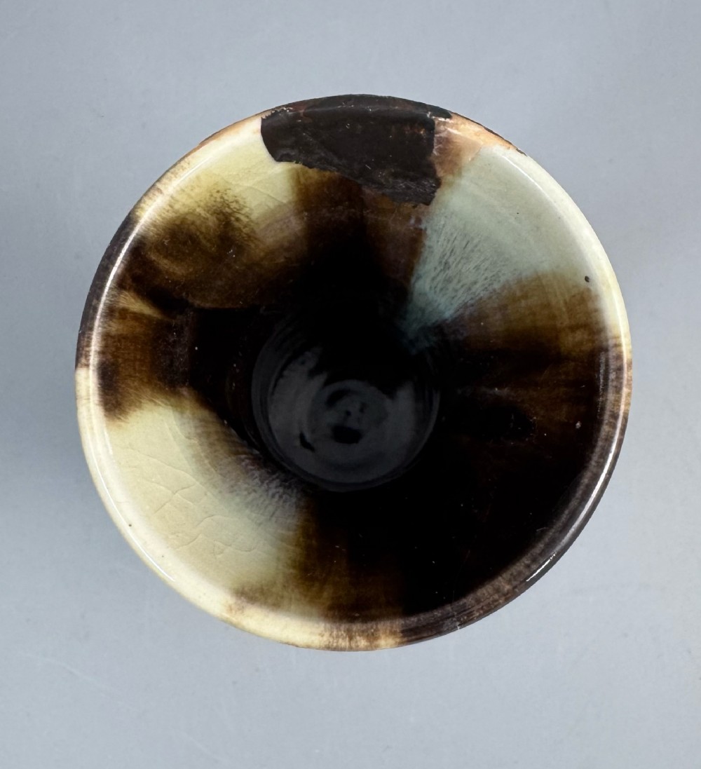 A Japanese Sumida Gawa stoneware vase featuring a ribbed cream body, dripping dark glaze along the flared rim, and an applied high-relief figure of a Rakan. View XI